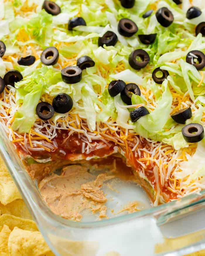 A glass casserole dish filled with 7 layer dip.