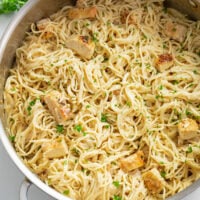 A skillet filled with Angel Hair Pasta with Chicken in a Parmesan Cream Sauce.