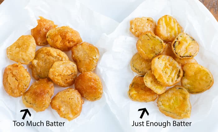Two types of battered and fried pickles on white wax paper.