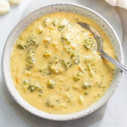 A bowl of Broccoli Cheese Soup with a spoon in it.