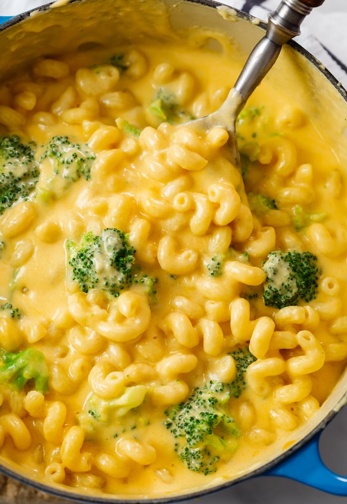 A dutch oven filled with Creamy Broccoli Mac and Cheese.