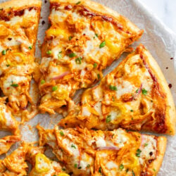 Buffalo Chicken Pizza cut into slices with buffalo sauce and blue cheese.