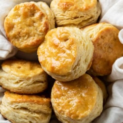 Golden Buttermilk Biscuits in a bowl with a cloth.