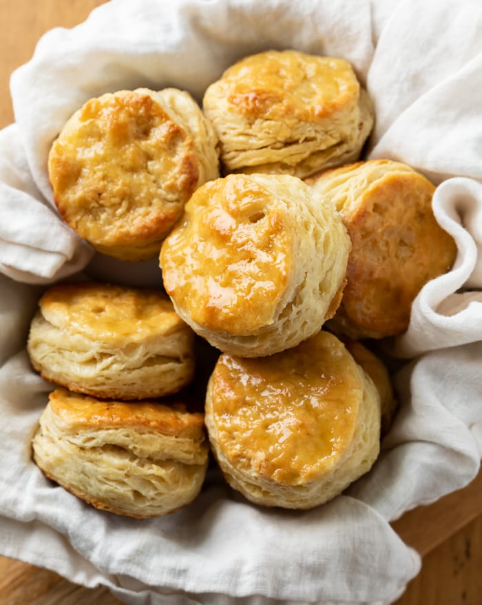 A bowl of buttermilk biscuits with a cloth underneath.