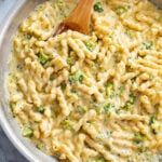 A skillet filled with Cheese Pasta with broccoli cheese sauce.