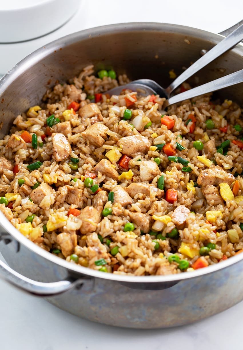 Chicken Fried Rice in a skillet with vegetables, green onions, eggs, and chicken.