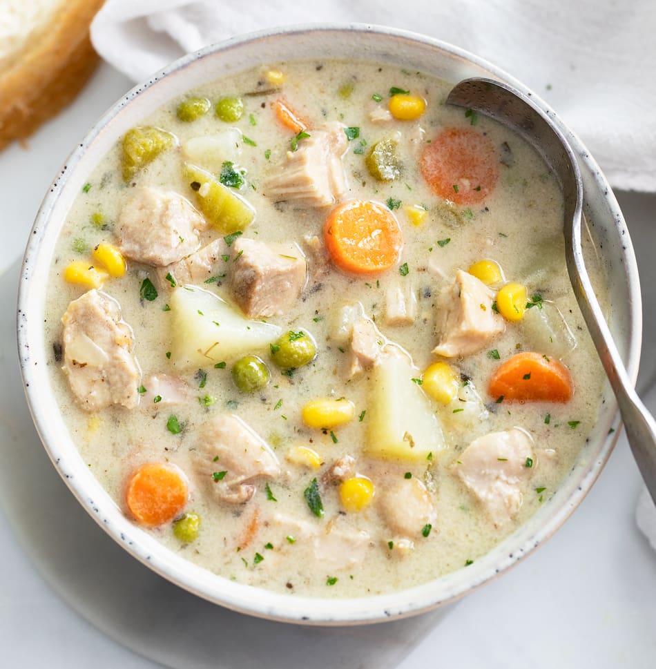 Creamy Chicken Soup in a white soup bowl with a spoon on the side.
