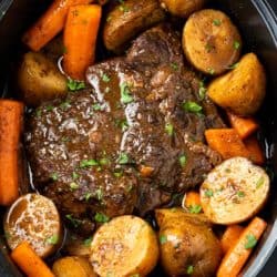 A Crock Pot Roast in a Crock with Potatoes, potatoes, and gravy.