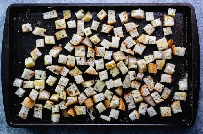 cubes of bread on a baking sheet before being baked to make homemade croutons.