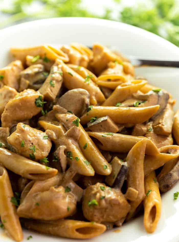 Close up image of De Vinci Pasta on a white plate with mushrooms and fresh parsley on top