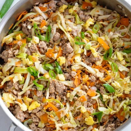 A skillet filled with Egg Roll in a Bowl with cabbage, carrots, pork, and scrambled eggs.