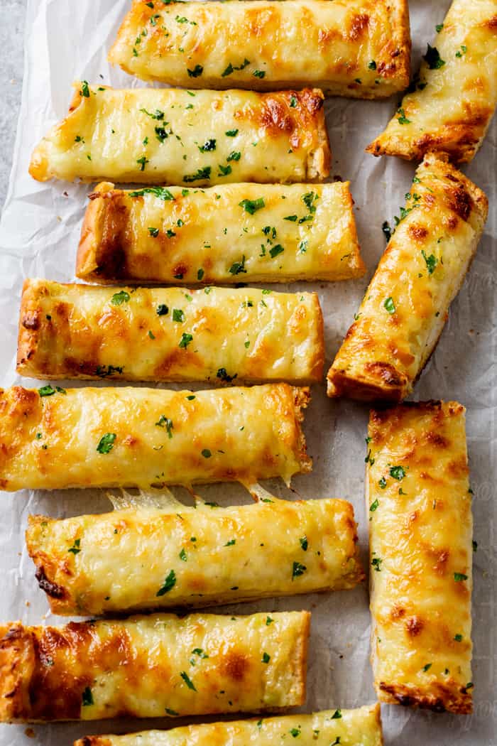 Sticks of Garlic Bread with Cheese topped with parsley.