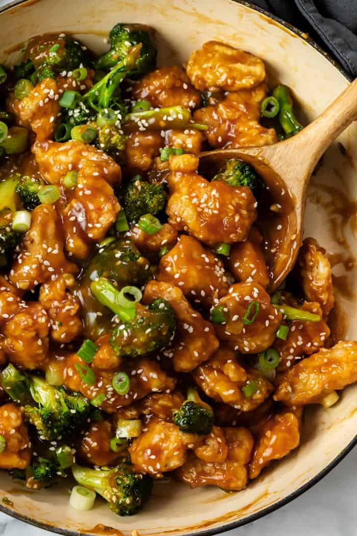 A skillet filled with General Tso's Chicken with broccoli.
