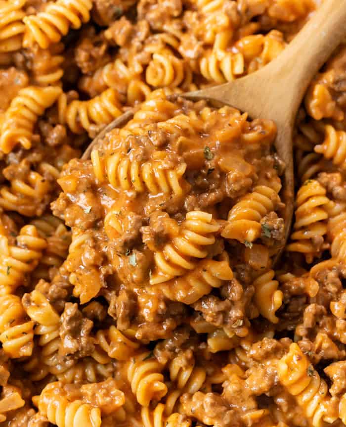 A wooden spoon full of creamy Ground Beef Pasta with Rotini noodles.