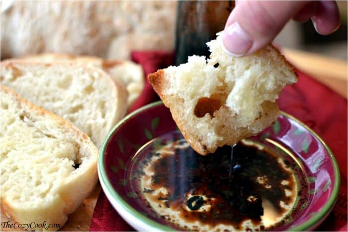 Hand Dipping Homemade Ciabatta bread in oil and balsamic.