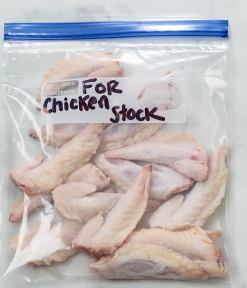 A quart sized freezer bag with chicken tips for making chicken stock.