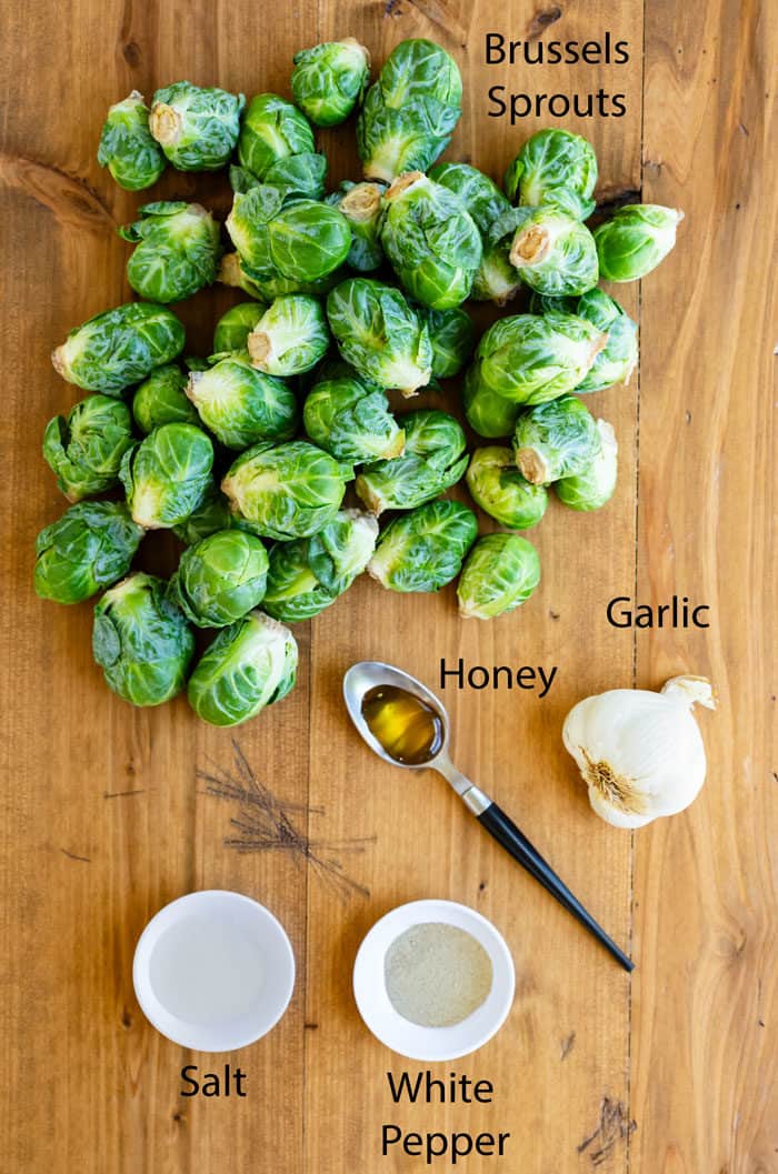 Ingredients for roasted brussels sprouts on a wooden table.
