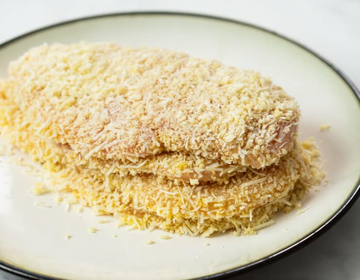 A stack of thin chicken covered in a Parmesan breadcrumb topping.