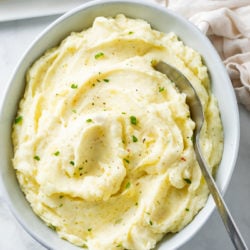 A white bowl filled with creamy homemade mashed potatoes.