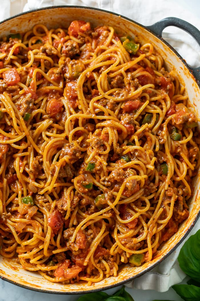 A pot filled with Spaghetti in meat sauce with bell peppers and diced tomatoes.