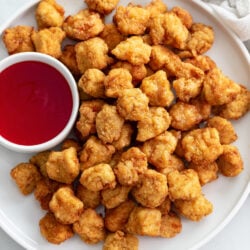 Popcorn Chicken on a white plate with sweet and sour sauce.