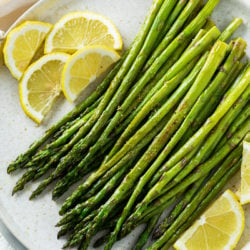 Roasted Asparagus on a plate with slices of lemon.
