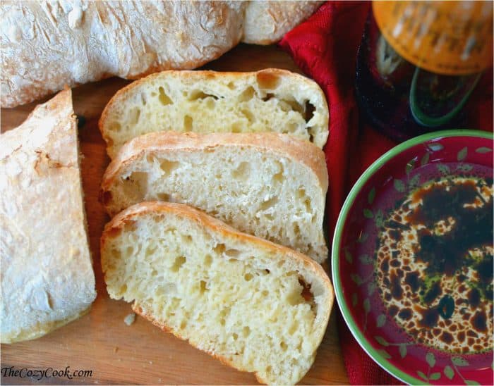 Slices of homemade ciabatta bread next to a dish of oil and balsamic for dipping.