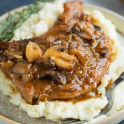 French Onion Smothered Pork Chops on a pile of mashed potatoes.