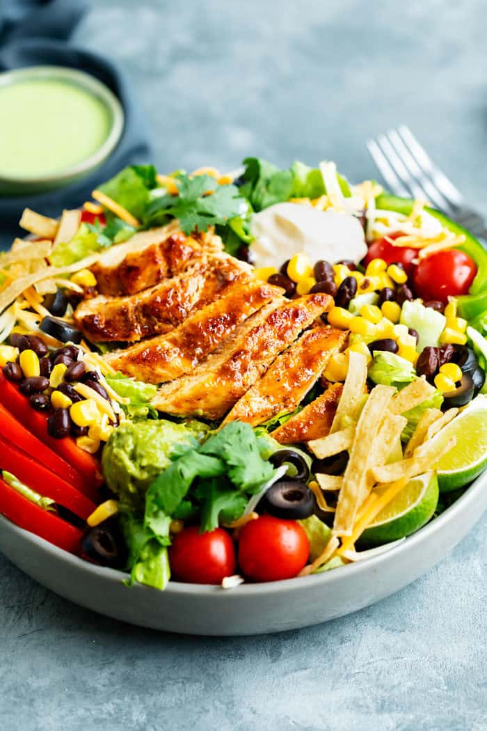 Close up view of a big bowl of Southwest salad with seared chicken on top.