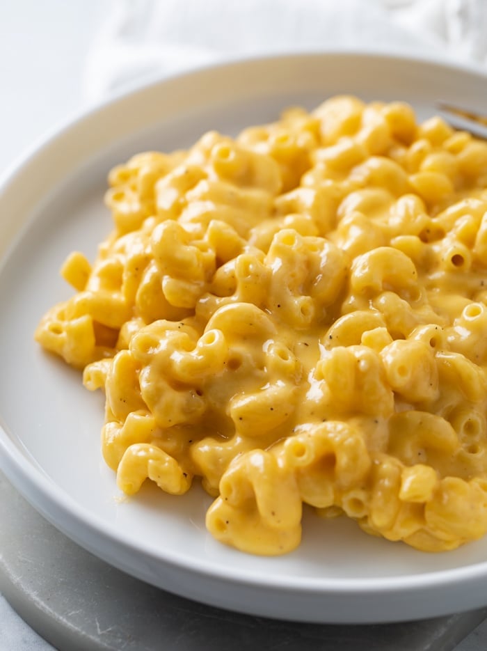 A white plate with creamy stovetop mac and cheese.