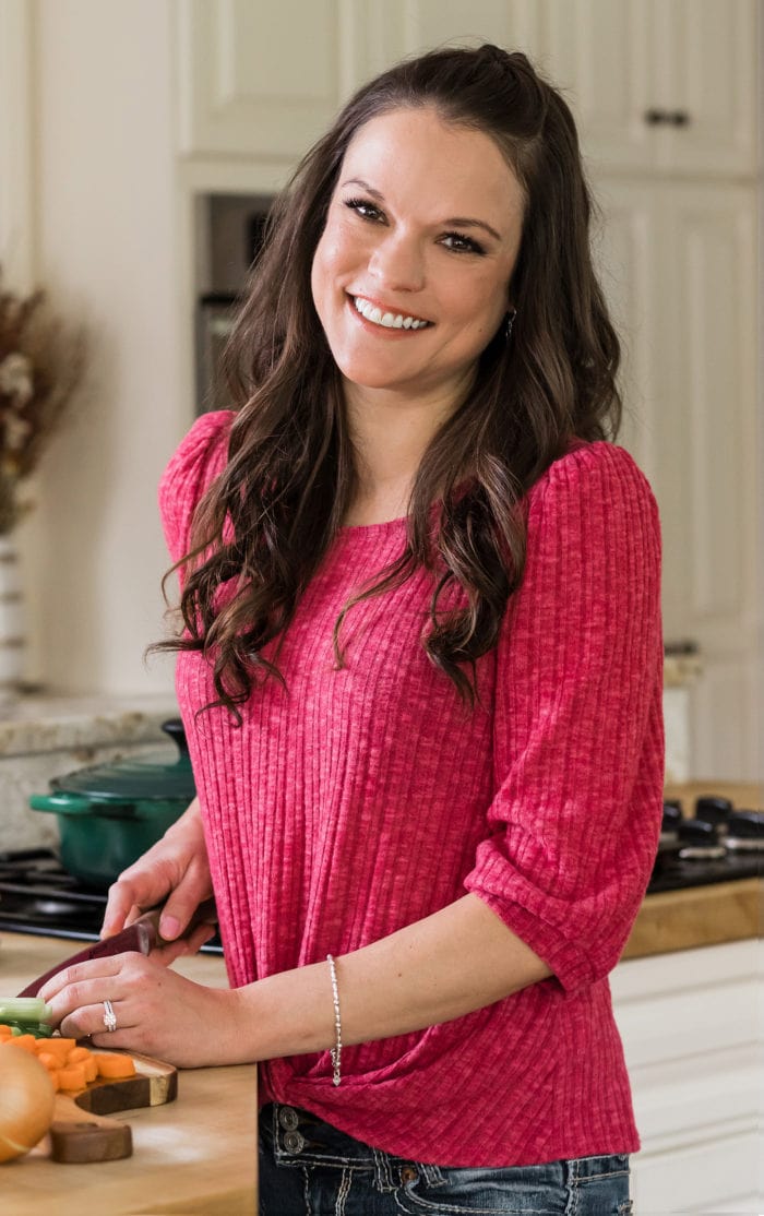 The Cozy Cook, Stephanie Melchione ,cooking in her kitchen and smiling.